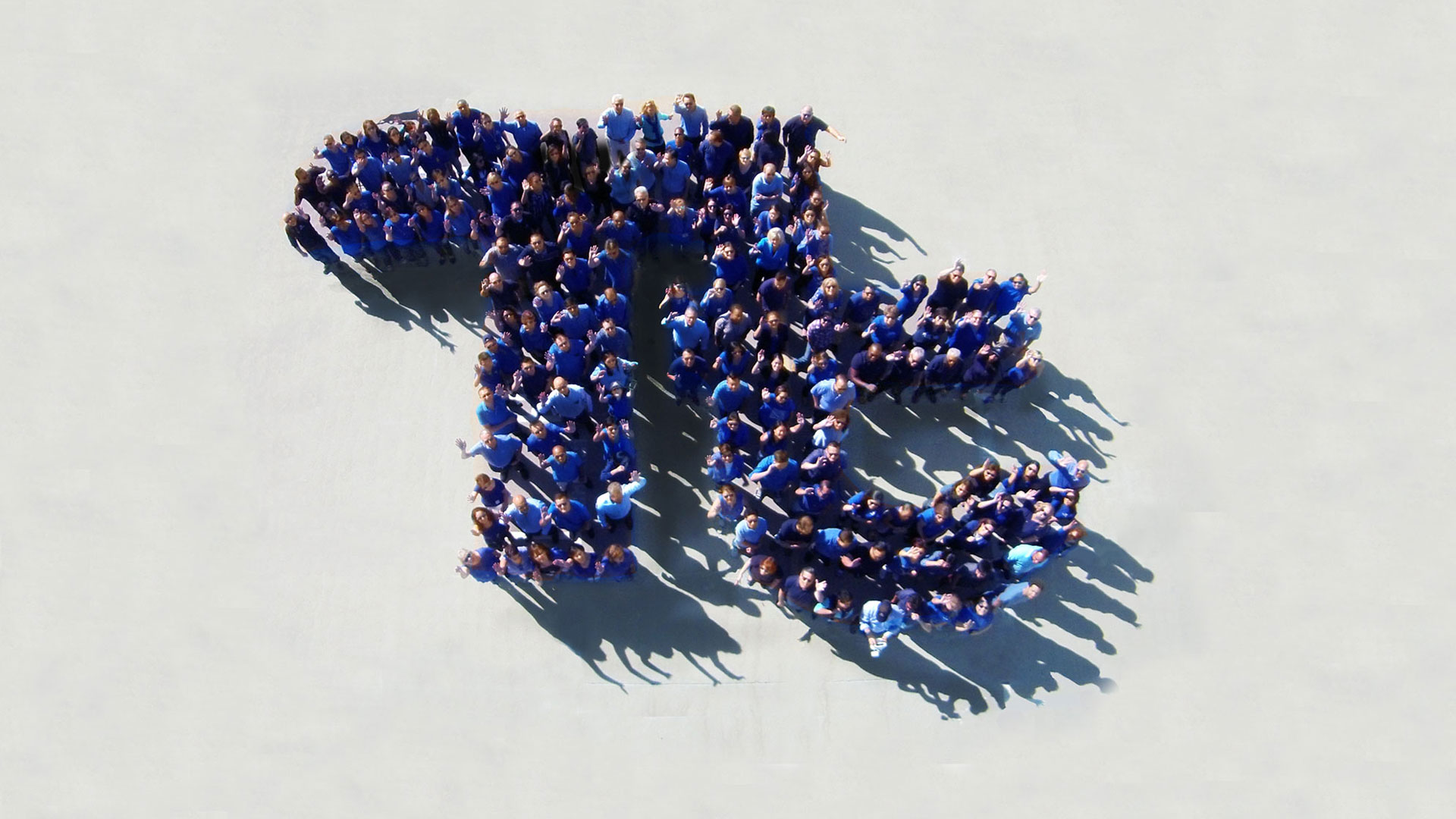 Trabalhadores da Tetra Tech fazem um mosaico humano com o formato da logo 'Tt'