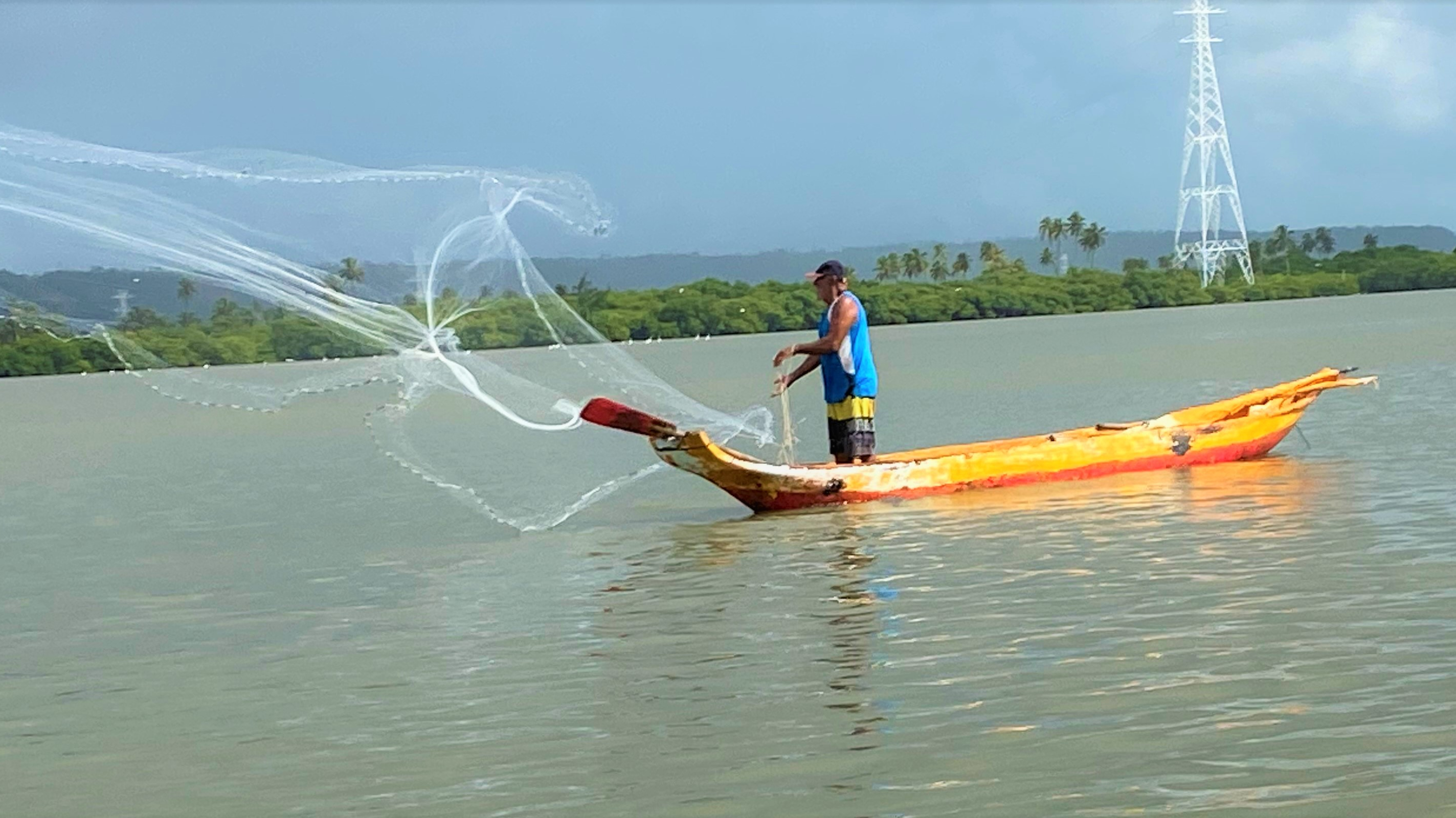 Morador pescando peixes em grande rio